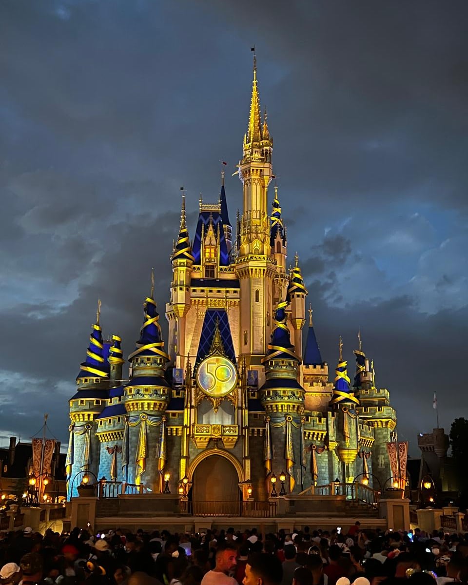 Castelo iluminado por projeções coloridas durante o show noturno